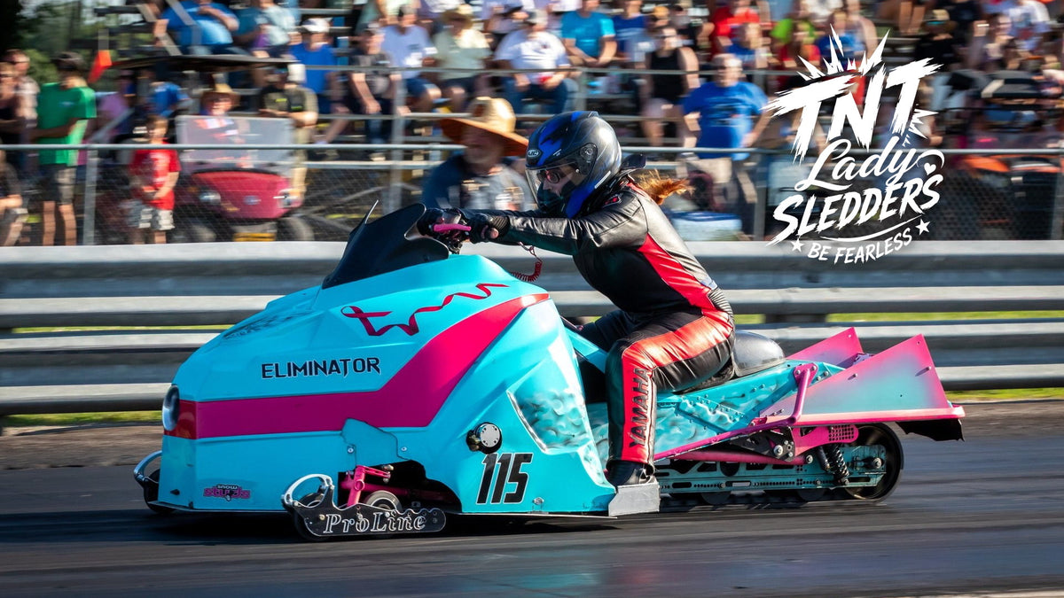 TNT Lady Sledders logo over Courtney launching a teal-and-pink drag sled in front of the grandstand