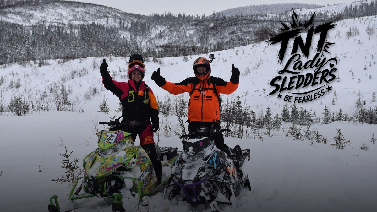 TNT Lady Sledders logo over two riders giving thumbs-up on their sleds in the Chocs, 2019